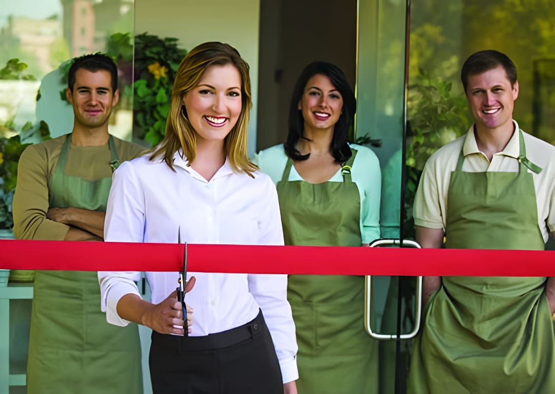 A group of people standing in front of a red ribbon.