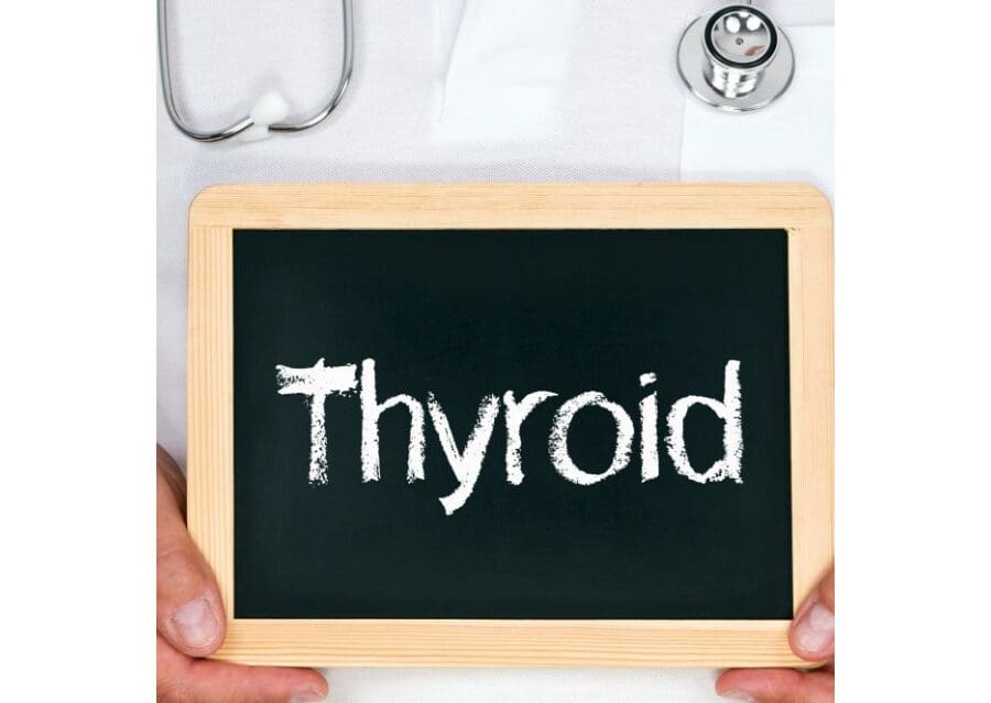 A person holding a chalkboard with the word thyroid written on it.