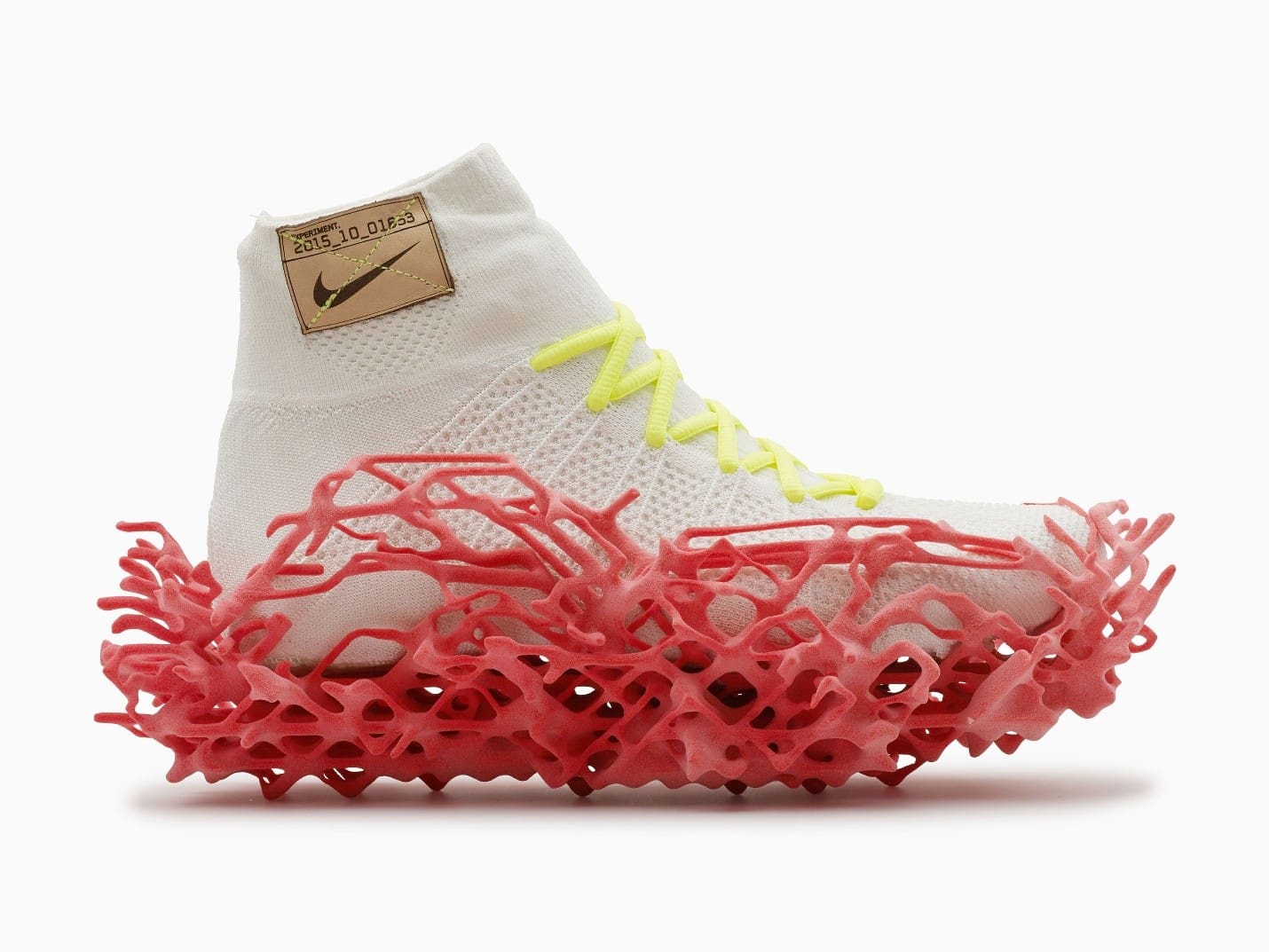 Experimental 3D-grown Nike shoe with a sculptural red sole and white knit upper.