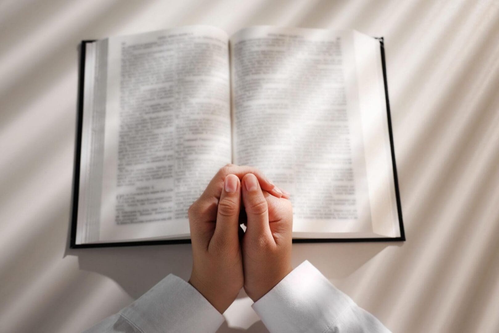 Prayer over an open Bible representing gratitude, faith and hope