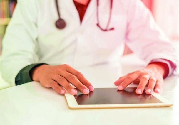 A doctor is using his tablet computer.
