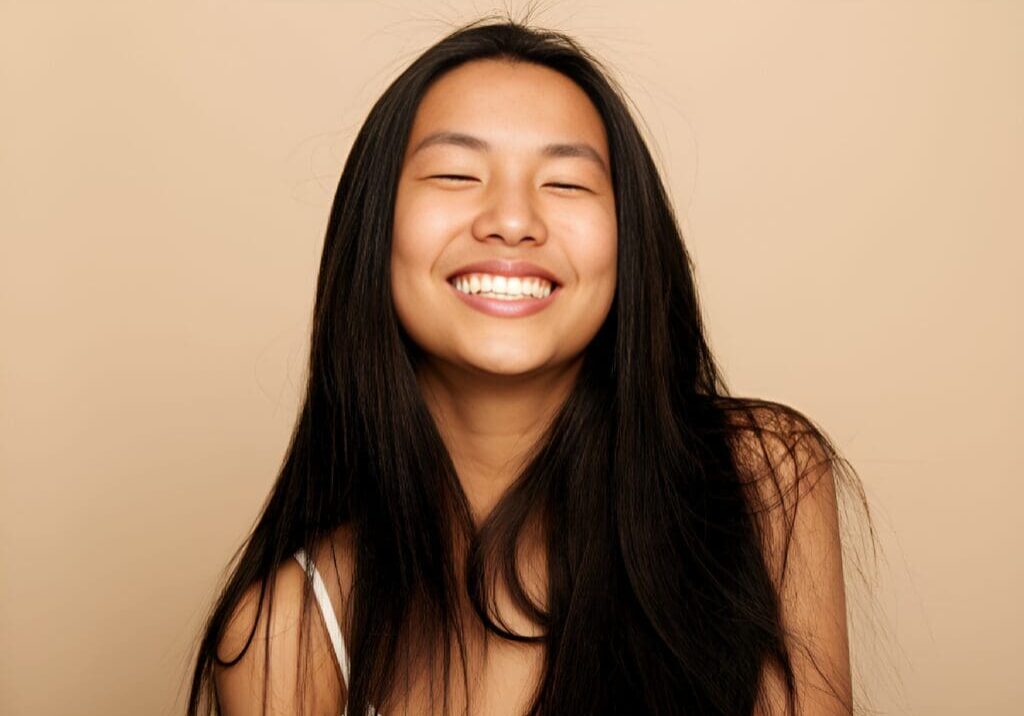 A woman with long hair smiling for the camera.