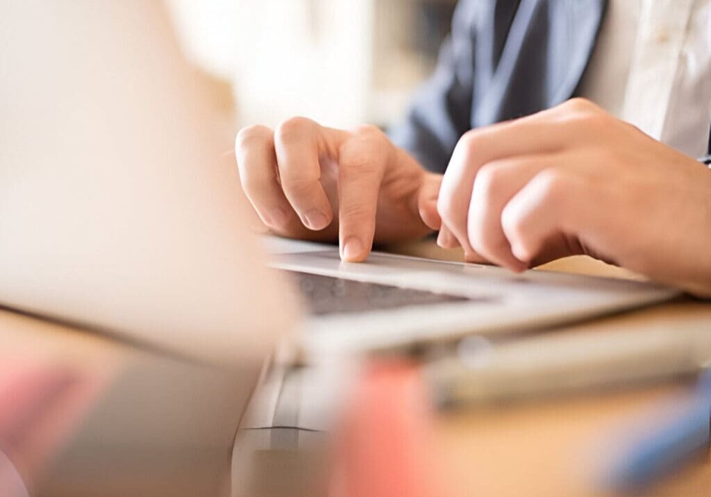 A person using their laptop on the table