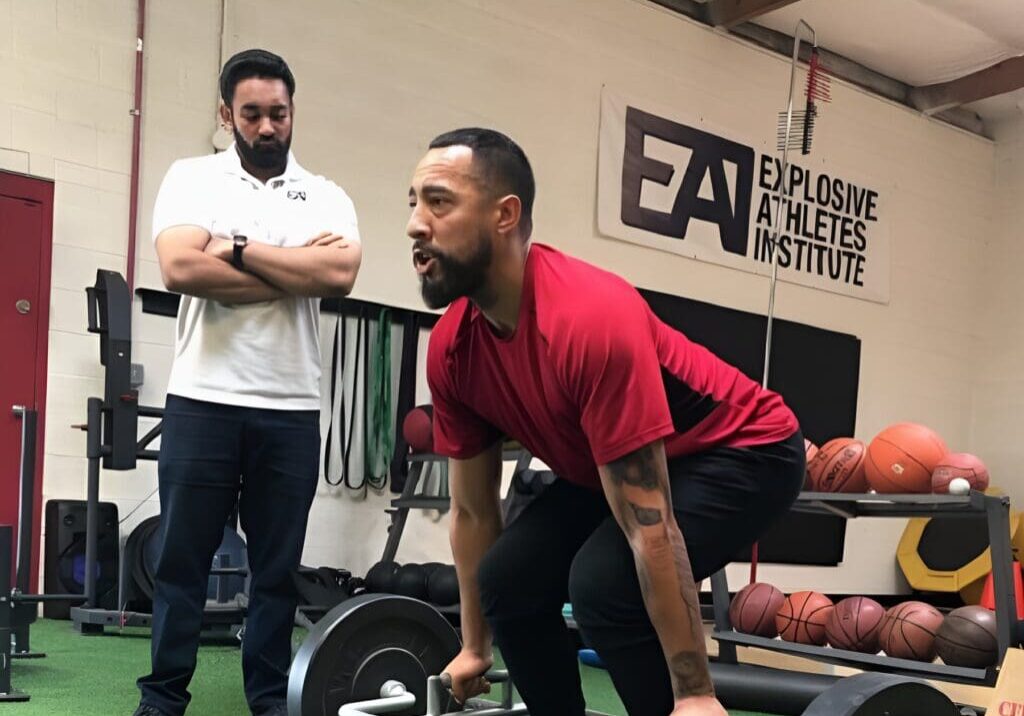 A man is lifting a barbell in the gym