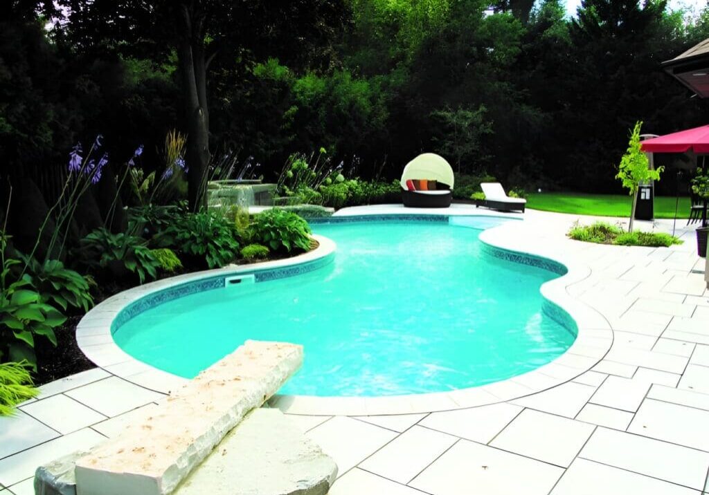 A pool with a bench and chairs in the middle of it.
