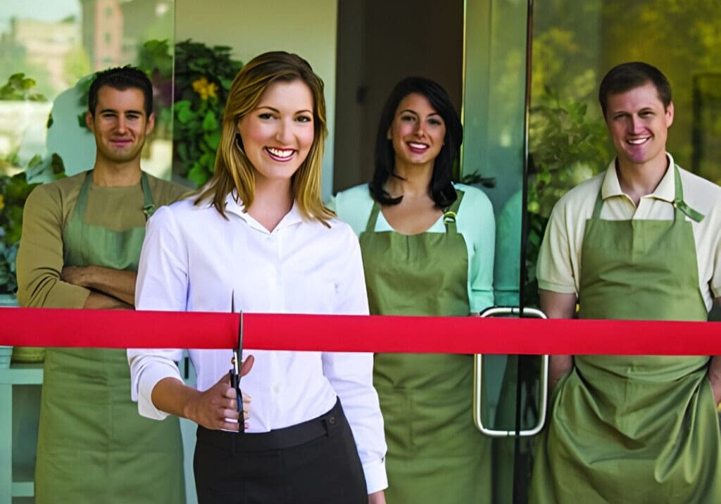 A group of people standing in front of a red ribbon.