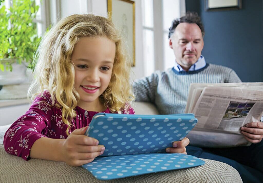 A girl is sitting on the couch with her father.