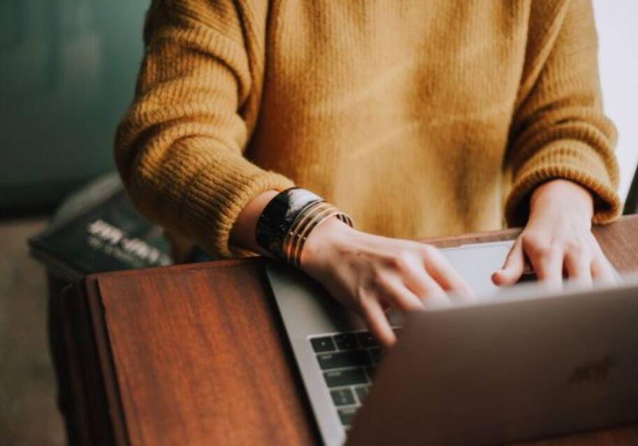 A person sitting at a table with a laptop.