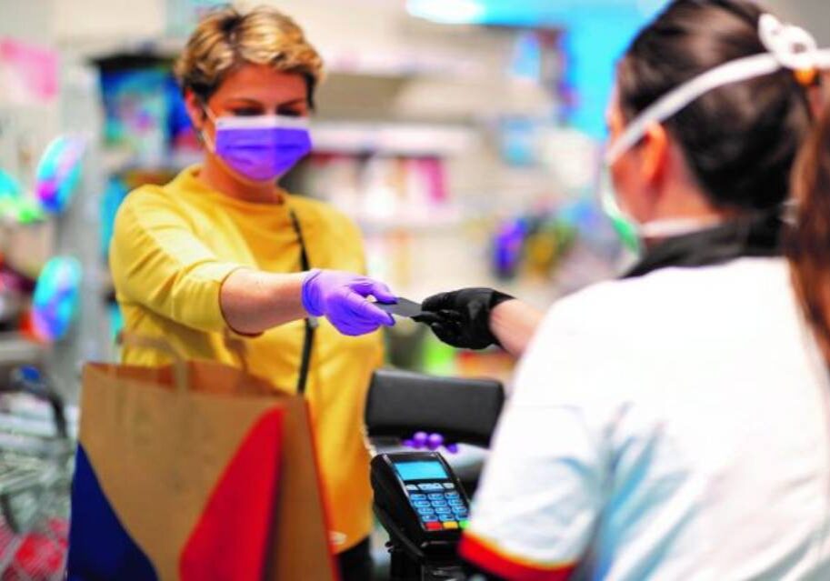 A woman in yellow shirt holding out her hand to someone else.
