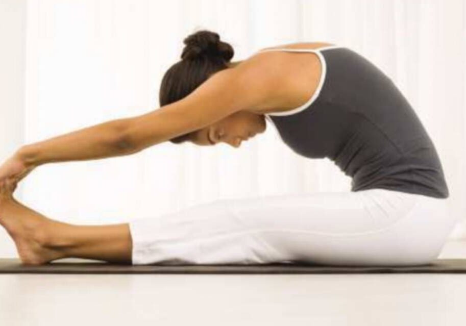 A woman is doing yoga on the floor