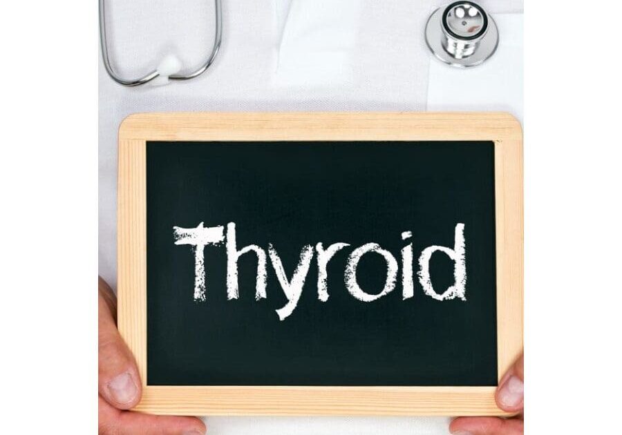 A person holding a chalkboard with the word thyroid written on it.