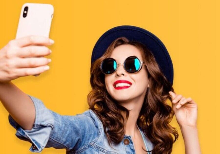 A woman taking a selfie with her phone.