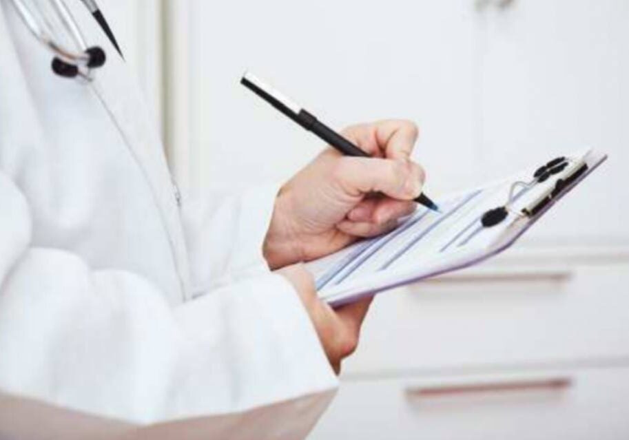 A person writing on paper with a pen.