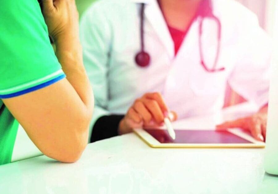 A doctor is sitting at the table with another person.