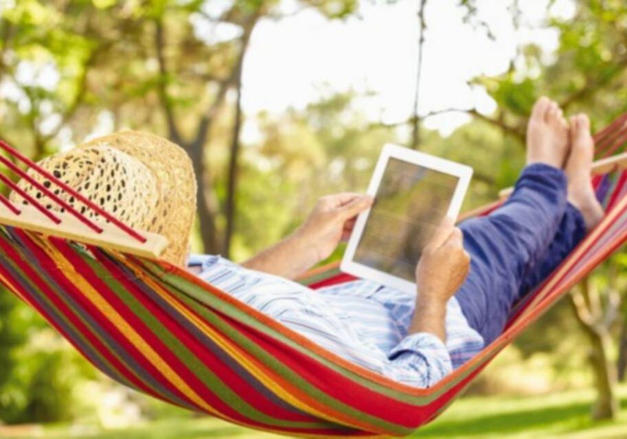 A person laying in a hammock with an ipad.