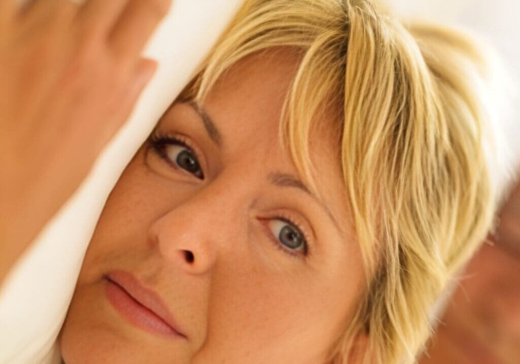 A woman with blonde hair and blue eyes looking at the camera.