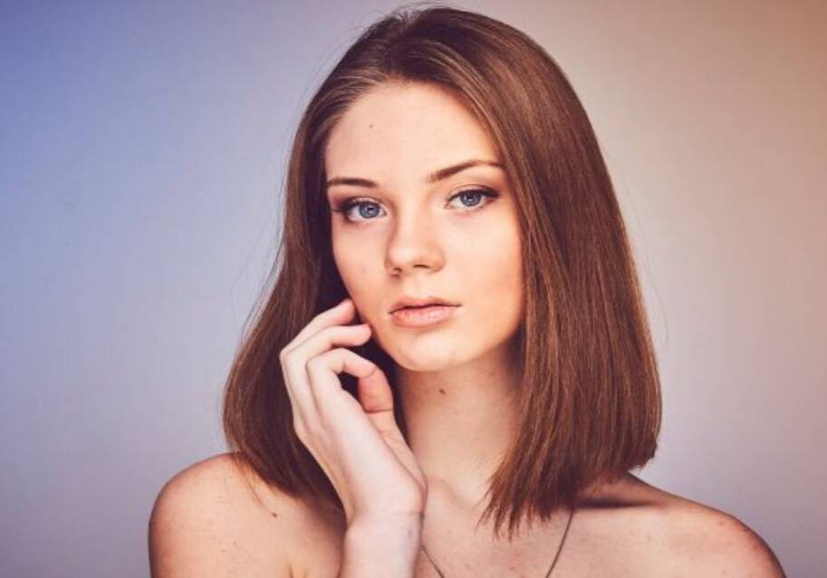 A woman with long hair is posing for the camera.