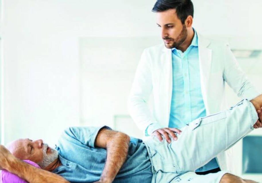 A doctor is examining the leg of a patient.