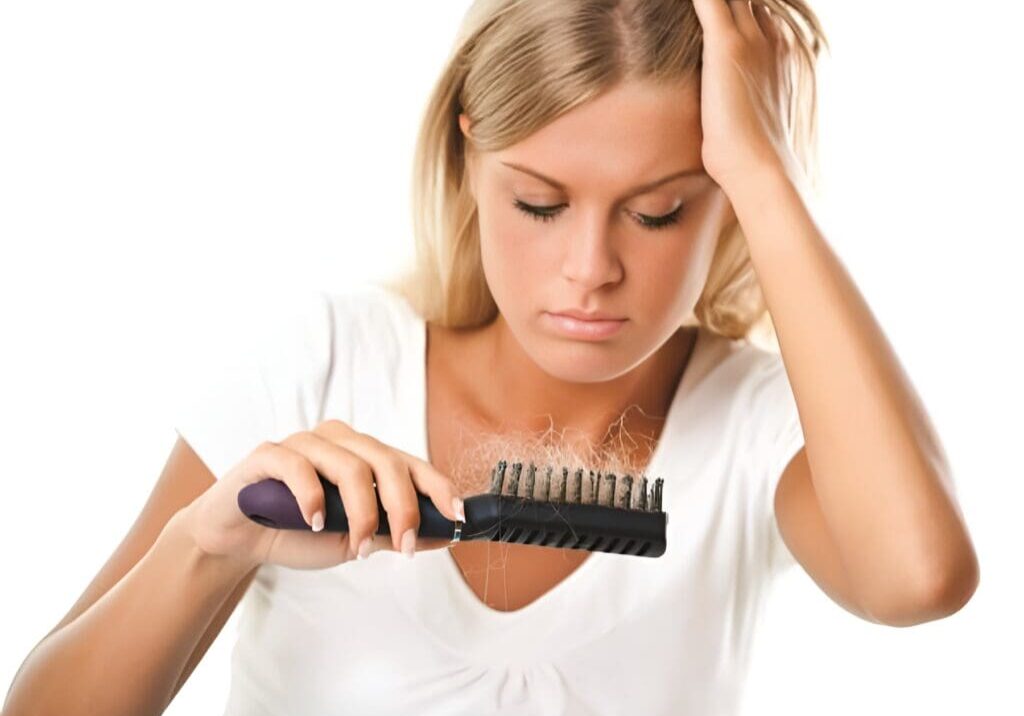 A woman is combing her hair with a brush.