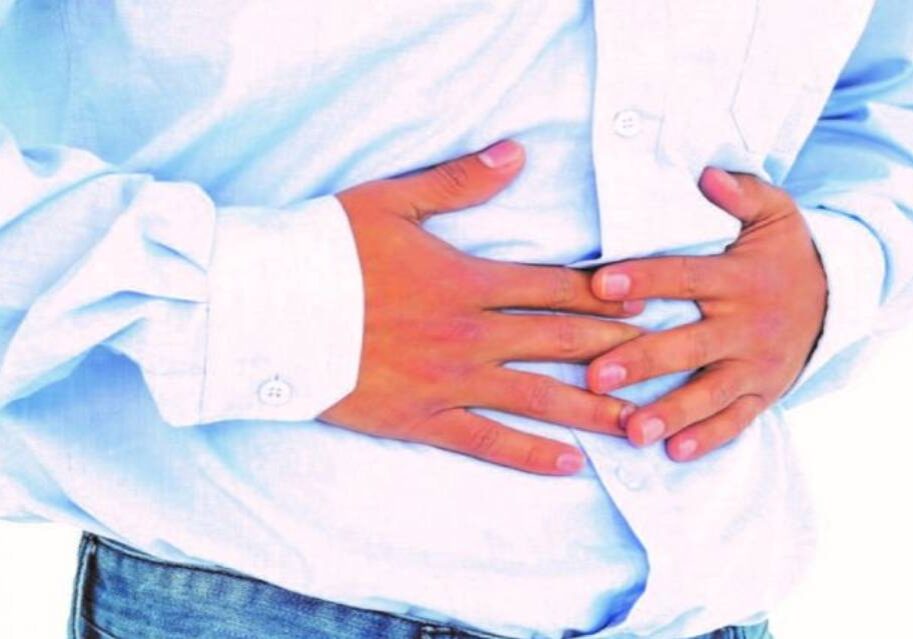 A person holding their stomach in the middle of his body.