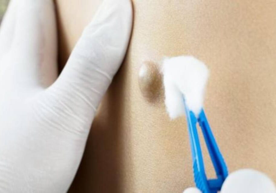 A person with white gloves holding something in their hand.