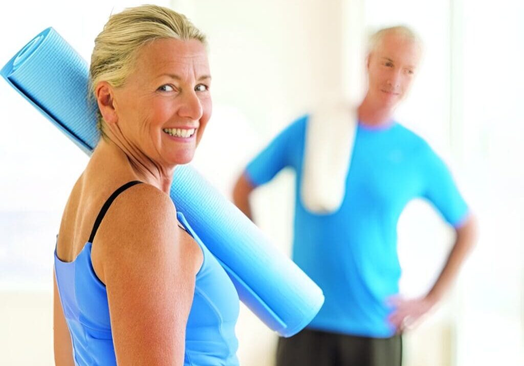 A woman holding a blue towel in front of an older man.