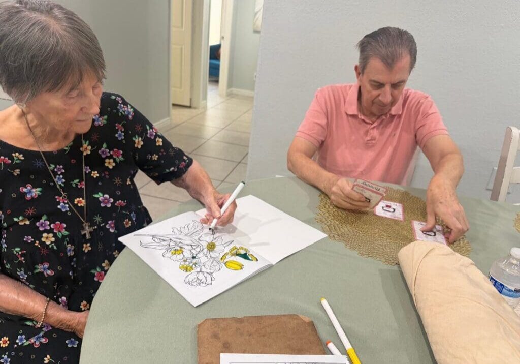 Residents at New Visions Assisted Living in Scottsdale enjoy coloring and card games during engaging indoor summer activities that promote social connection and healthy aging.