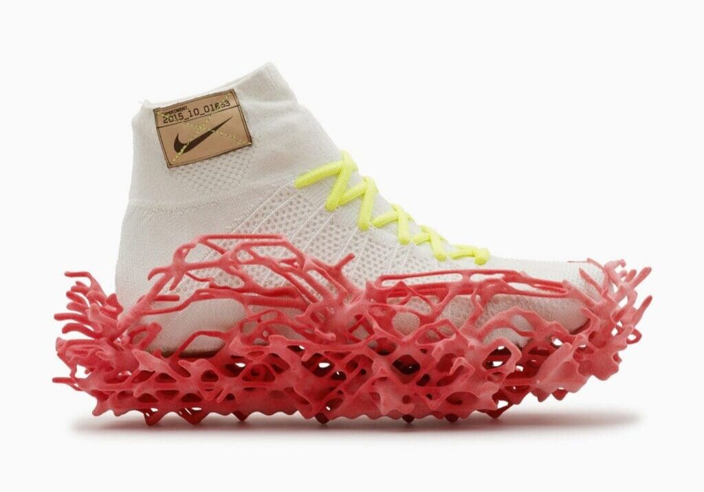 Experimental 3D-grown Nike shoe with a sculptural red sole and white knit upper.